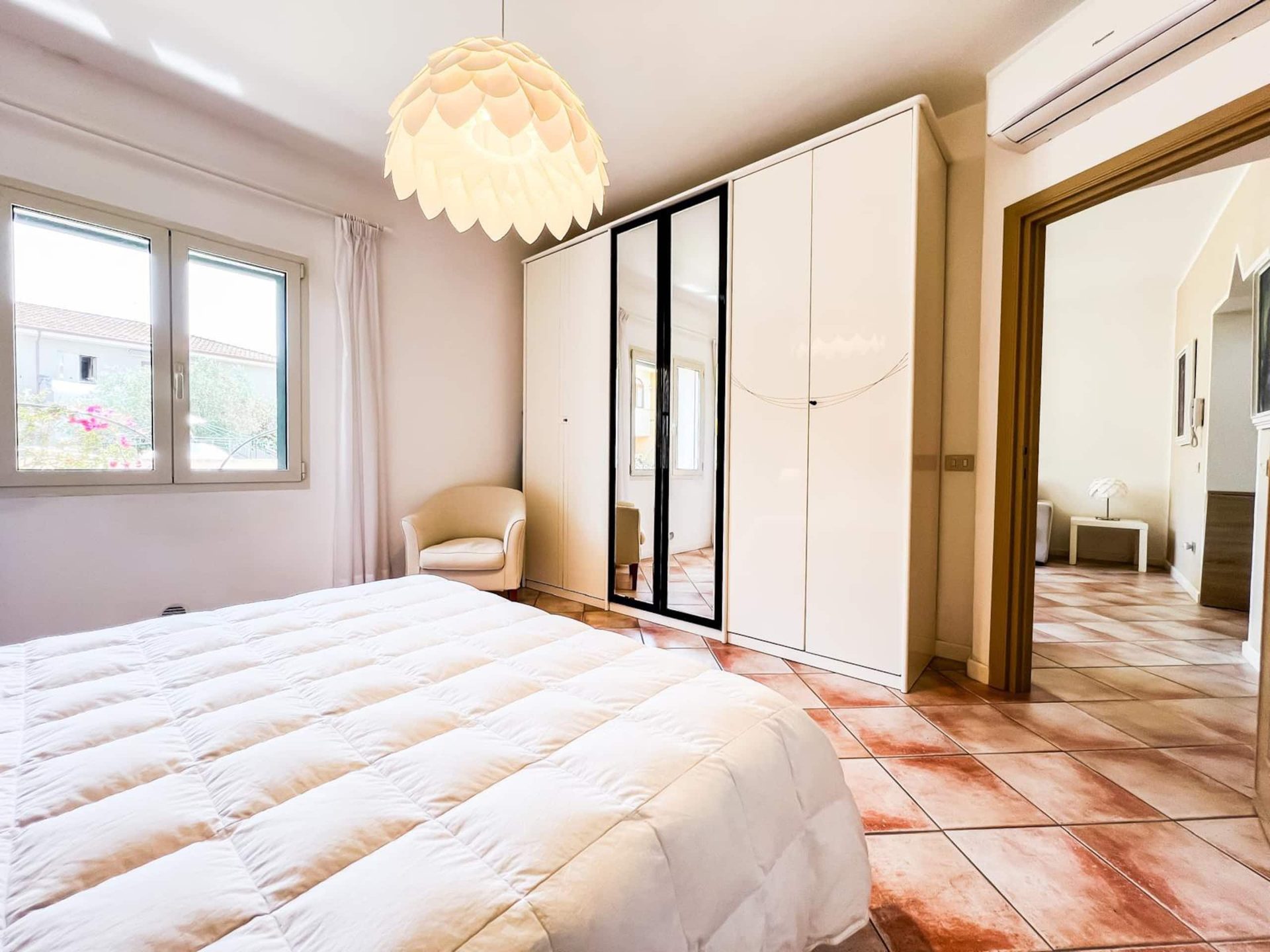 Il letto matrimoniale visto dalla finestra, con l'armadio bianco a lato