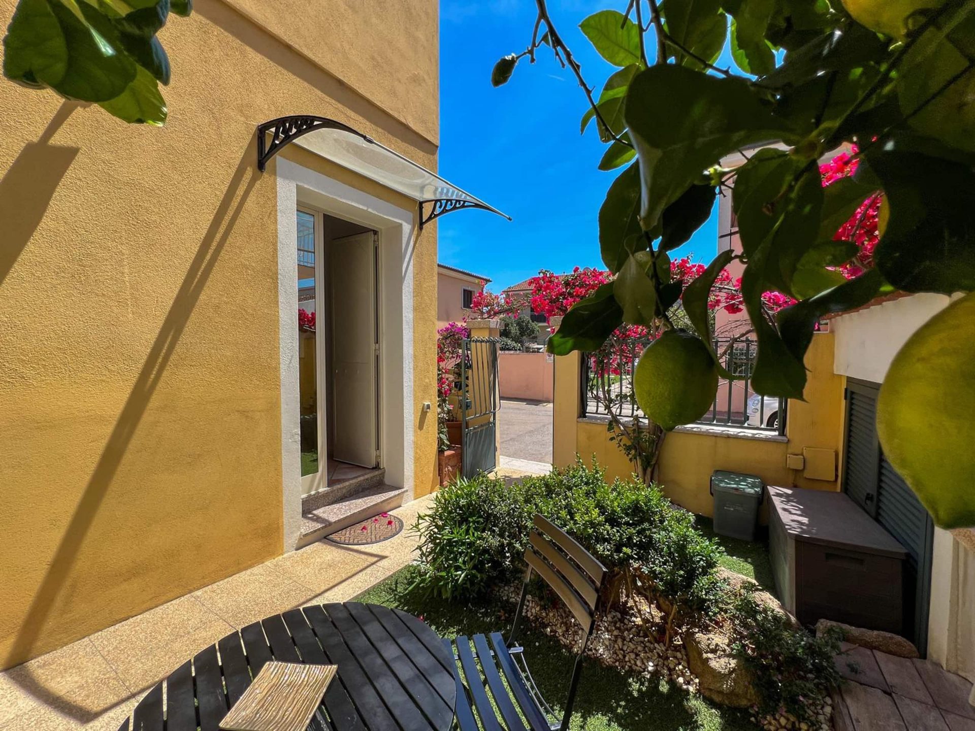 L'ingresso indipendente dell'appartamento, con la tettoia sopra la porta e il tavolino in giardino