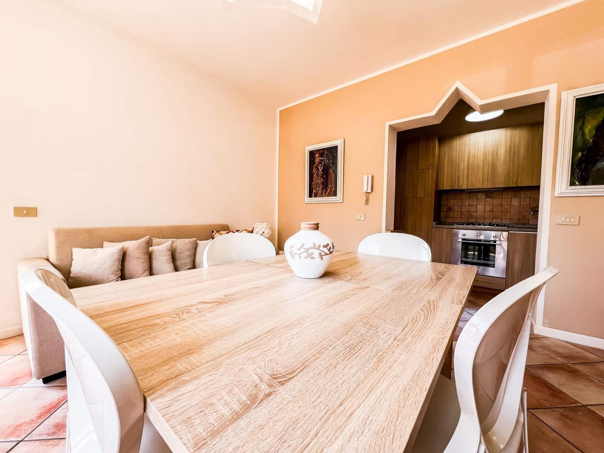 Il tavolo da pranzo in legno chiaro con le sedie bianche